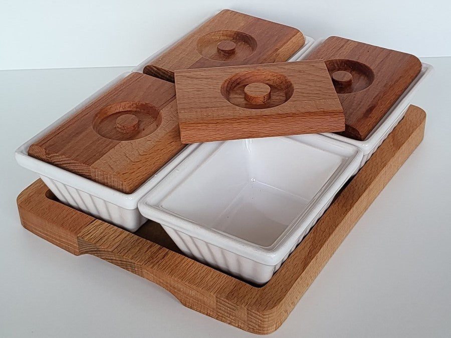 4 Tapasschalen aus weißem Keramik mit Holzdeckeln auf Holztablett